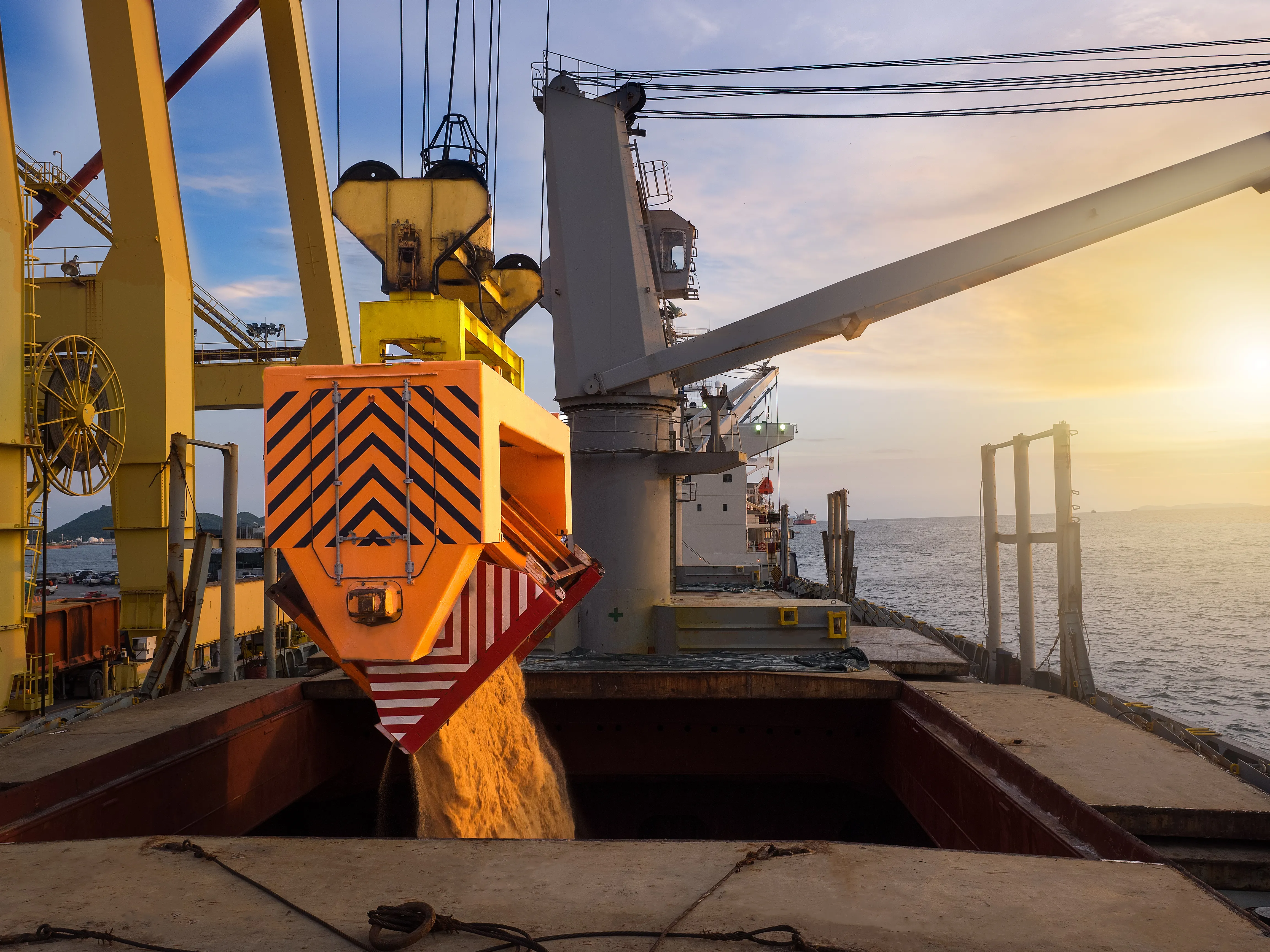 Bulk carrier being loaded with sugar at sunset